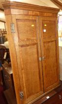 An early 19th century oak and mahogany cross banded double door hanging corner cupboard, height