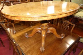 A mid-Victorian figured walnut oval tilt-top pedestal breakfast table, raised on hipped scroll