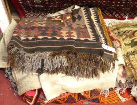 A collection of Persian, Turkish, and further middle eastern rugs, wall hangings and saddle bags,