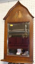 A Dutch early 20th century oak bevelled wall mirror, the lancet arched top inlaid with figures, 65 x