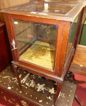 An early 20th century walnut single door glazed display cabinet, having interior glass shelf and