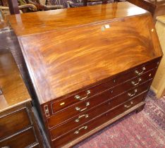 A George III mahogany slope front writing bureau, having a fitted interior over four long