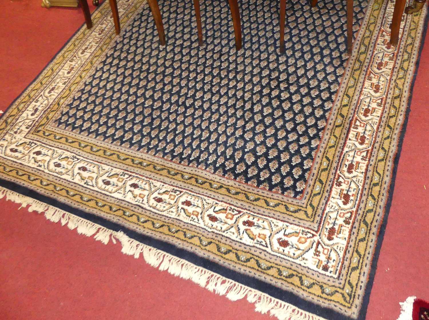 A Persian woollen blue ground Bokhara rug, the central floral repeating ground within trailing