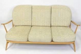 An Ercol blond beech stickback three-seater 'Windsor' sofa, having slightly pronounced arm rests,