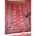 A Persian woollen red ground Bokhara hall rug, 160 x 96cm Some minor wear to edges.Otherwise appears