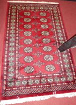 A Persian woollen red ground Bokhara hall rug, 160 x 96cm Some minor wear to edges.Otherwise appears