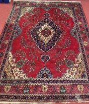 A large Persian woollen red ground Shiraz rug, 377x300cm