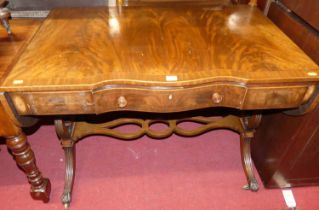 A flame mahogany and cross banded sofa table, the rounded drop ends raised on reeded outswept