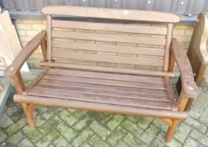 A stained and slatted wood two-seater garden bench, w.128cm