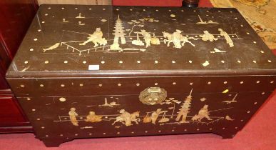 An Eastern camphorwood and mother of pearl inlaid hinge top blanket chest, decorated with figure