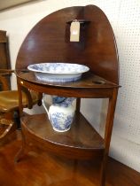 An early 19th century mahogany two-tier bow front corner wash stand, with blue & white transfer