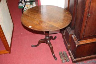 An early 19th century provincial oak circular tilt-top pedestal tripod table, dia. 76cm