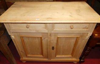 A provincial French pine double door side cupboard, having twin upper drawers and fluted detail,