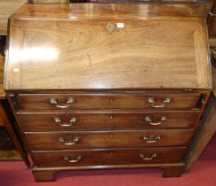 A George III mahogany slope front writing bureau, having a fitted interior over four long