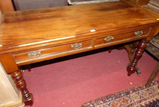 An Edwardian walnut two-drawer side table, raised on ring turned and lower square cut supports,