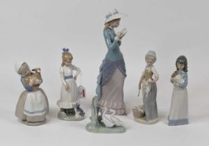 A Lladro porcelain figure of a lady, shown standing reading a book, h.35cm; together with five Nao