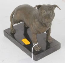 A bronzed metal model of a dog, shown standing on a polished hardstone plinth, h.13cm