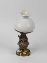 A late 19th century novelty oil lamp, having an opaline glass shade over brass burner and pottery