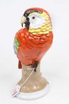 A Rosenthal porcelain model of a parrot, shown seated upon a stump, h.29cm Tip of tail broken.