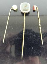 A Victorian gilt metal and bloodstone set tie-pin; together with two other gilt metal tie-pins (3)