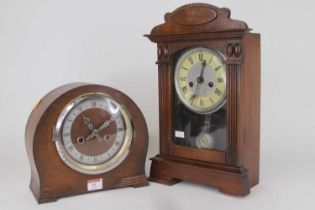 An early 20th century American stained pine cased mantel clock, having painted chapter ring with