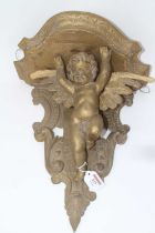 A carved pine and later gilt painted wall bracket in the form of a cherub, h.40cm