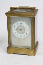 A brass carriage clock, the enamelled chapter ring showing Arabic numerals, having visible