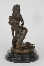 A bronzed metal figure of a nude woman, modelled kneeling upon a circular plinth mounted to a