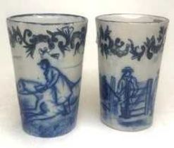 A pair of 18th century Delft blue and white beakers, each of tapering form, decorated with hunting