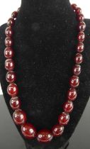 A beaded cherry amber necklace, arranged as 31 graduated barrel beads; together with other sundry