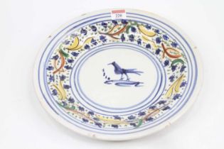 A French faience polychrome charger, decorated to the centre with a bird, dia.31cm