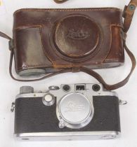 A vintage Leica SLR camera, No. 512585, with leather case