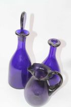 A blue glass decanter and stopper, of mallet shape, h.34cm; together with a purple art glass jug;