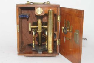 A 19th century lacquered monocular microscope, having an adjustable stage above a Y-shaped foot,