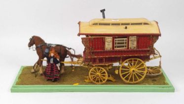 A painted wooden model of a 'gypsy' caravan, standing on a painted wooden base, w.75cm (a/f)