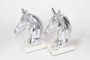 A pair of polished metal horse head busts, mounted to hardstone plinths, h.23cm