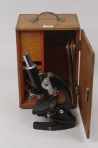 A late 20th century black powder-coated metal monocular microscope, h.25cm, with oak case