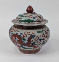 A Chinese porcelain jar and cover, of squat baluster form, painted with a five-claw dragon chasing a