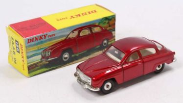 A Dinky Toys No. 156 Saab 96 saloon, comprising of metallic red body with white interior and spun