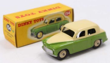 A Dinky Toys No. 154 Hillman Minx saloon, comprising green lower and cream upper body, with cream