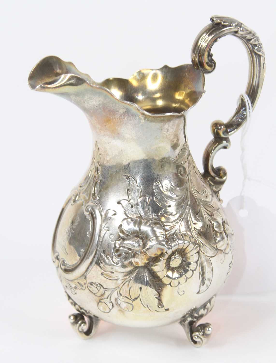 A Victorian silver cream jug, of baluster shape, having scrolled acanthus handle and floral repousse