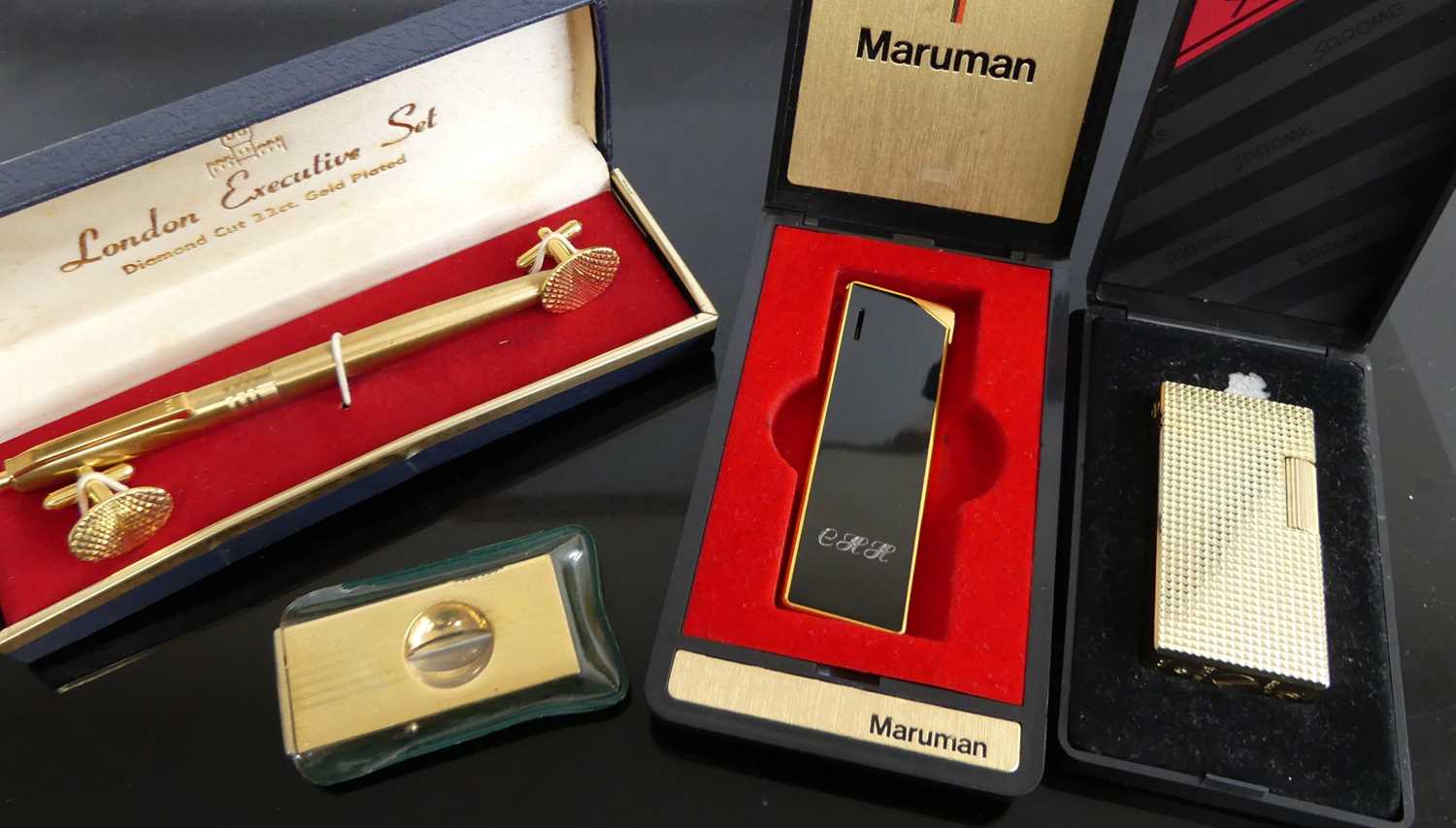 A gent's cased cigar cutter, Sarome pocket lighter in fitted case, one other by Maruman, and a cased