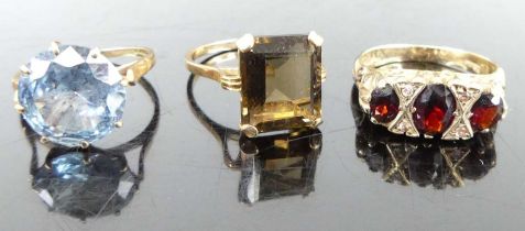 A 9ct gold blue topaz set dress ring; together with a 9ct gold smoky quartz dress ring; and a 9ct