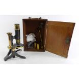 A brass monocular microscope, stamped J White Glasgow to the base, cased with accessories