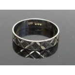 A modern silver and engraved wedding band, size N