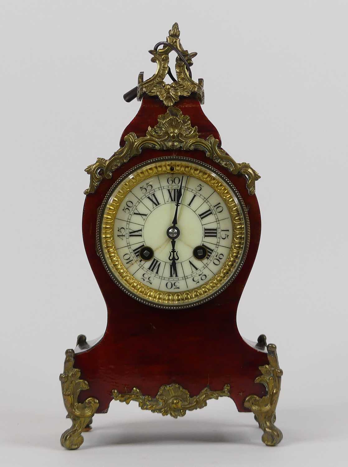 An early 20th century mantel clock, in the Rococo taste, the enamel dial showing Roman numerals,