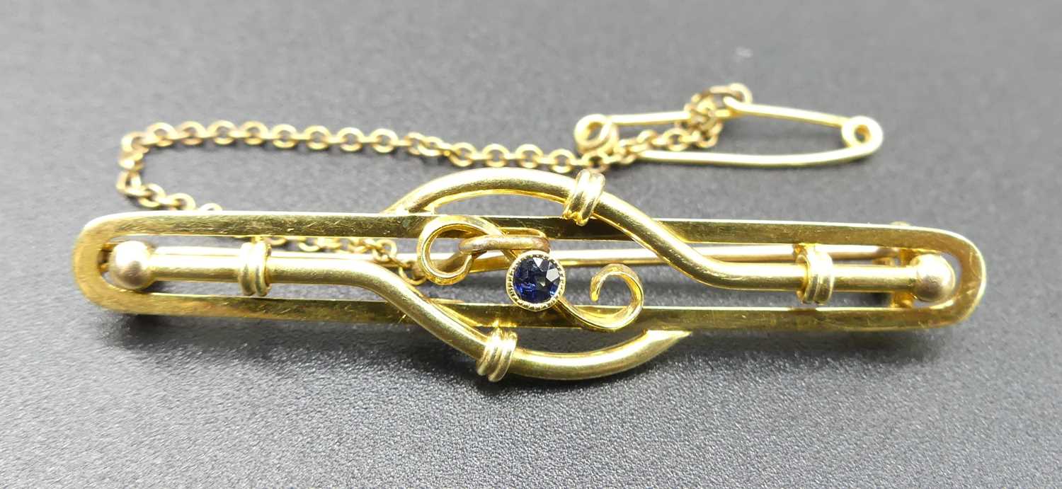 An Edwardian 15ct gold and sapphire set bar brooch, with safety chain, 4.1g, 5cm
