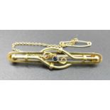 An Edwardian 15ct gold and sapphire set bar brooch, with safety chain, 4.1g, 5cm