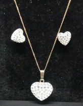 A modern 9ct gold and cz set heart shaped pendant on finelink neck chain, together with matching ear