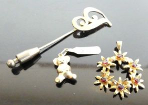 A yellow metal garnet set flower head pendant, unmarked but tests as approx 9ct gold, 2.9g, dia.